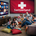 A warm and cozy living room where a diverse family, including children and adults, is gathered on a couch and floor, watching a large-screen television. The TV screen displays various Swiss IPTV channels, while a prominent flag with the word 'Switzerland' is shown on another screen in the background. The scene captures a joyful and relaxed atmosphere as they enjoy streaming entertainment together, highlighting the experience of IPTV Schweiz services. With high-quality streaming, an extensive selection of IPTV Schweiz channels, and seamless multi-device compatibility, this setup ensures an immersive viewing experience for all. Whether looking for the Best IPTV Schweiz Service Providers (2025) or exploring premium Swiss IPTV options, users can enjoy top-tier content with ease."
